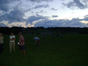 Moth Mingle attendees climb through the fields of Franklin Farms to set a light trap. 